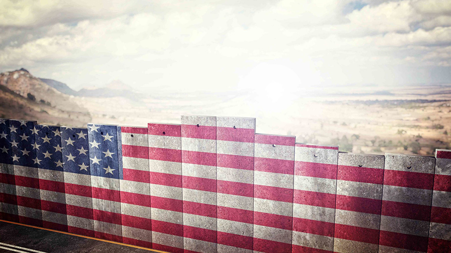 Um muro pintado com a bandeira dos EUA se encontra na margem de uma rodovia. Maconha.