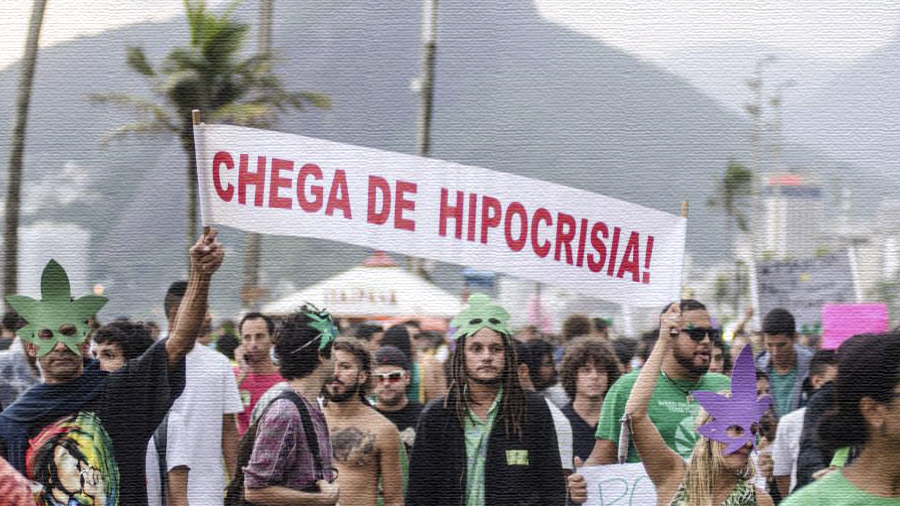 Fotografia de manifestantes levantando uma faixa branca com os dizeres em vermelho “Chega de hipocrisia!”, durante a Marcha da Maconha do Rio de Janeiro, em 2014. Senad.