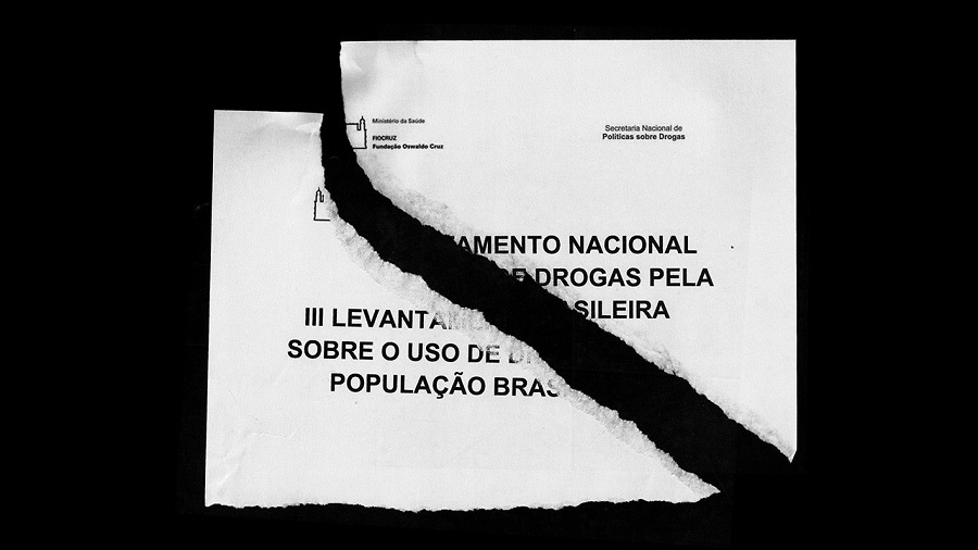 Fotografia mostra duas partes rasgadas da capa do relatório que resultou do 3º Levantamento Nacional Domiciliar sobre o Uso de Drogas realizado pela FioCruz, com um fundo preto.