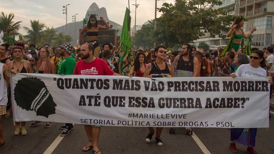 #PraCegoVer: Fotografia mostra manifestantes durante a Marcha da Maconha no Rio, carregando uma faixa onde podemos ler a frase: "Quantos mais vão precisar até que essa guerra acabe?
