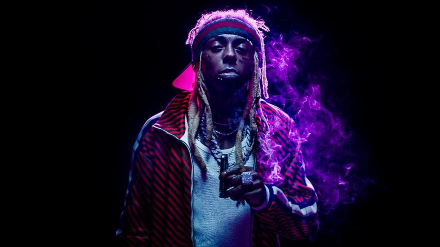 Fotografia de Lil Wayne, em fundo preto e iluminação roxa focada no rapper, que olha para a câmera, enquanto segura um vape da Gkua com a mão esquerda, com detalhe para um grande anel no dedo médio; seu lado esquerdo é permeado por uma fumaça que ficou roxa em razão da luz.