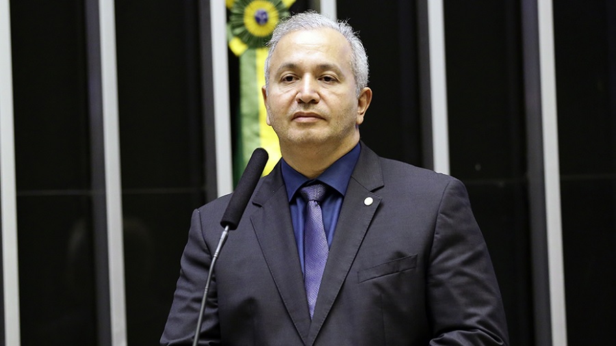 Fotografia, em primeiro plano, do deputado Eduardo Costa, usando terno em tons de roxo e atrás do microfone da tribuna da Câmara. Foto: PTB.