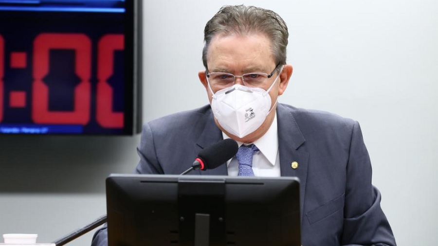 Fotografia que mostra Luciano Ducci, de máscara branca, sentado atrás do monitor e microfone de mesa. Imagem: Cleia Viana / Câmara dos Deputados.