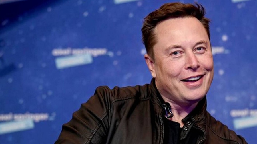 Fotografia, em primeiro plano, de Elon Musk sorridente, enquanto inclina o corpo para o lado, com fundo em tons de azul e branco. Imagem: reprodução / Instagram.