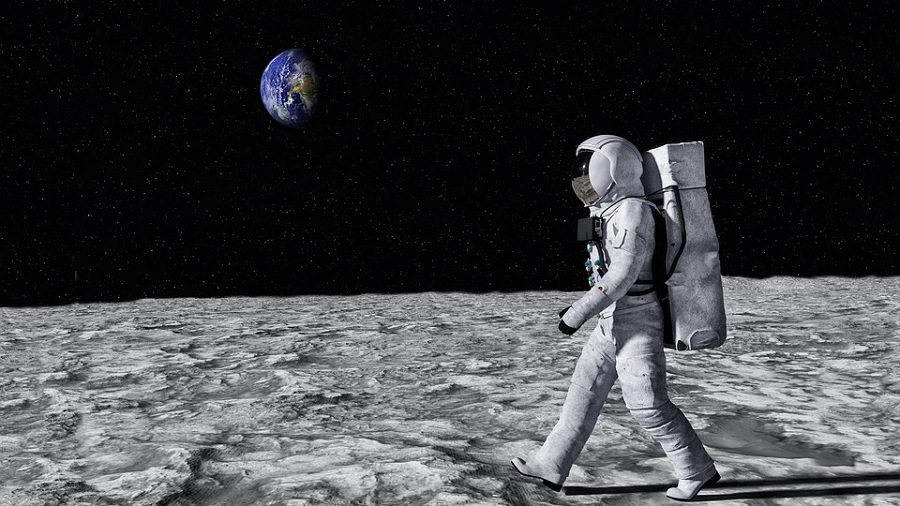 Imagem mostra um astronauta andando sobre o solo da Lua e, na parte superior esquerda do quadro, o planeta Terra. O horizonte do satélite contrasta com o céu escuro. Crédito: Tumisu / Pixabay.