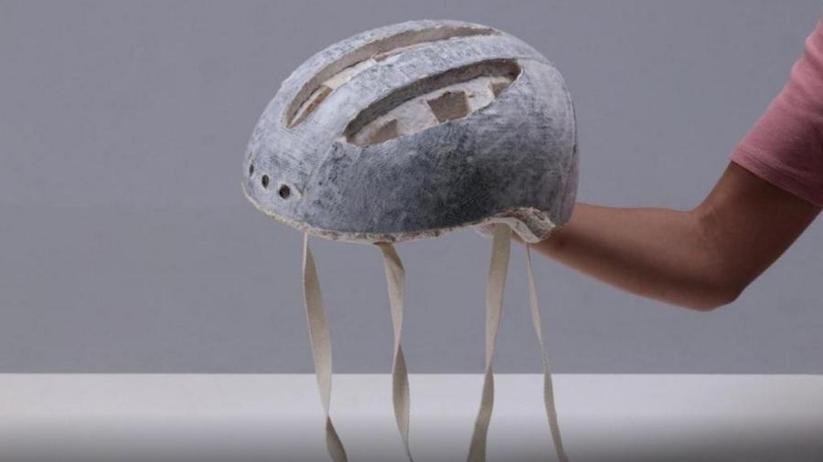 Fotografia mostra um protótipo do capacete feito de cânhamo e micélio, que tem o revestimento interno e tiras de cor bege-claro e exterior cinza. Imagem: Divulgação.