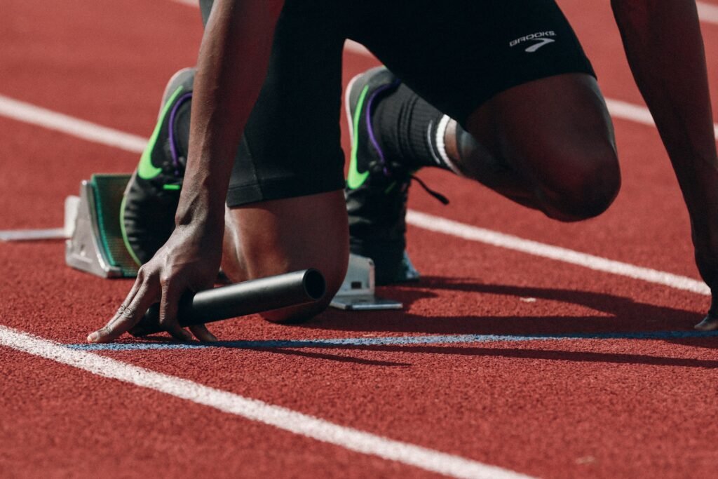 Fotografia mostra parte de um atleta de revezamento preparado para a corrida. Foto Braden Collum-Unsplash