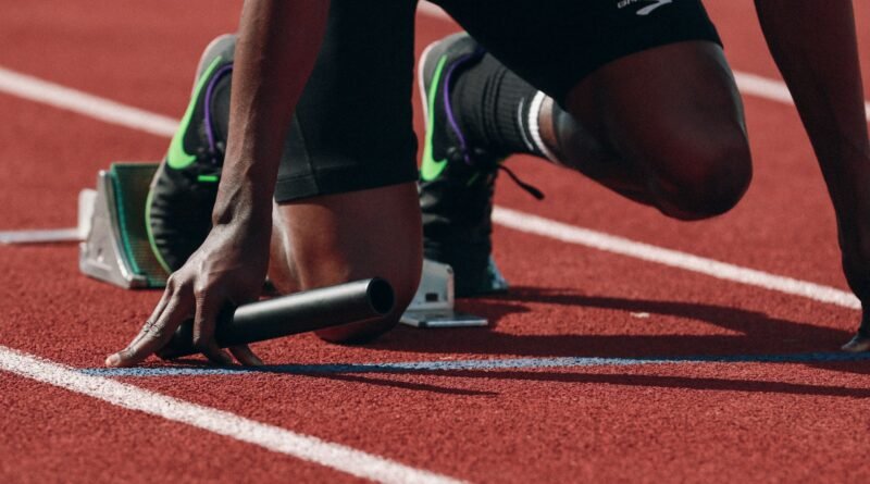 Fotografia mostra parte de um atleta de revezamento preparado para a corrida. Foto Braden Collum-Unsplash