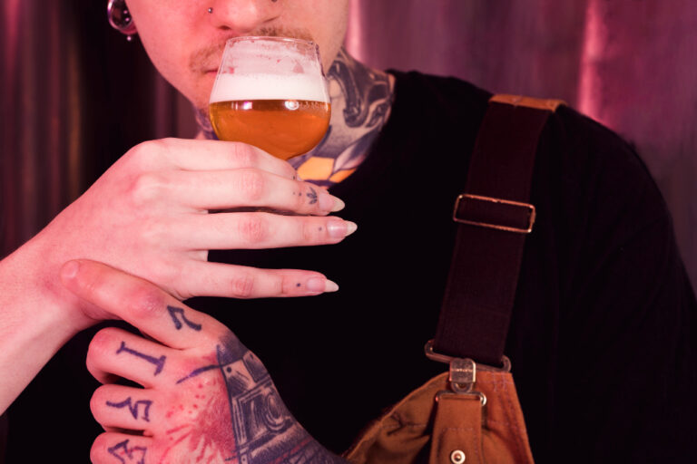 Imagem mostra um homem sentindo o aroma de um copo de cerveja segurado pela mão de uma mulher. Foto: freepik.