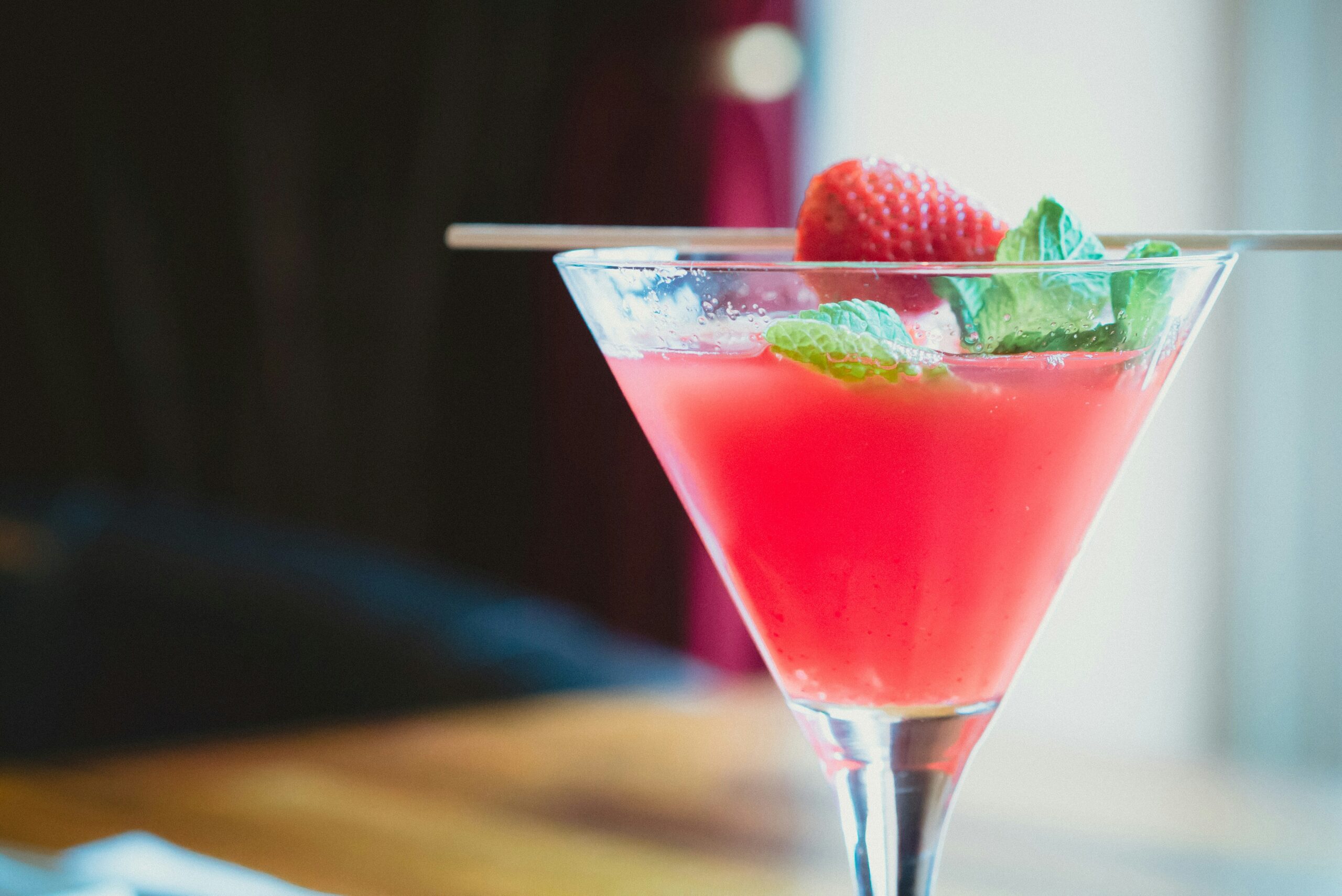 Drinque de álcool de cor rosa. Foto: Jens Theess Unsplash